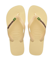 Load image into Gallery viewer, Photograph of a pair of pale yellow Havaianas flip-flops with textured straps and a Brazilian flag logo