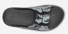 Load image into Gallery viewer, A single slide sandal shown from a top-down view, featuring a gray and black camouflage pattern on the upper strap and a solid black textured sole with the 'ofoos' brand logo embossed on the heel.