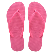 Load image into Gallery viewer, Pair of bright pink Havaianas flip-flops featuring textured rubber soles and visible brand logos on straps and footbed