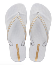 Load image into Gallery viewer, Pair of white flip-flops with gold accents on a white background
