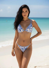 Load image into Gallery viewer, Woman wearing a blue and white floral bikini on a beach
